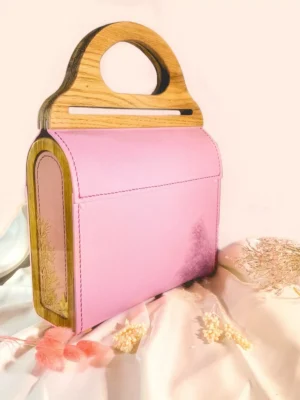 A handmade bag with natural leather, an oak handle, and epoxy resin inserts with
